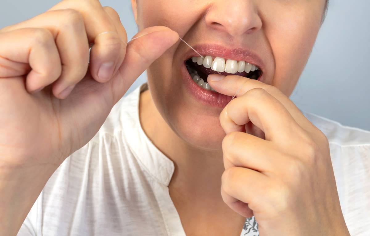 Anonymous close-up image of a person flossing their teeth, emphasizing the importance of dental health and daily hygiene routines