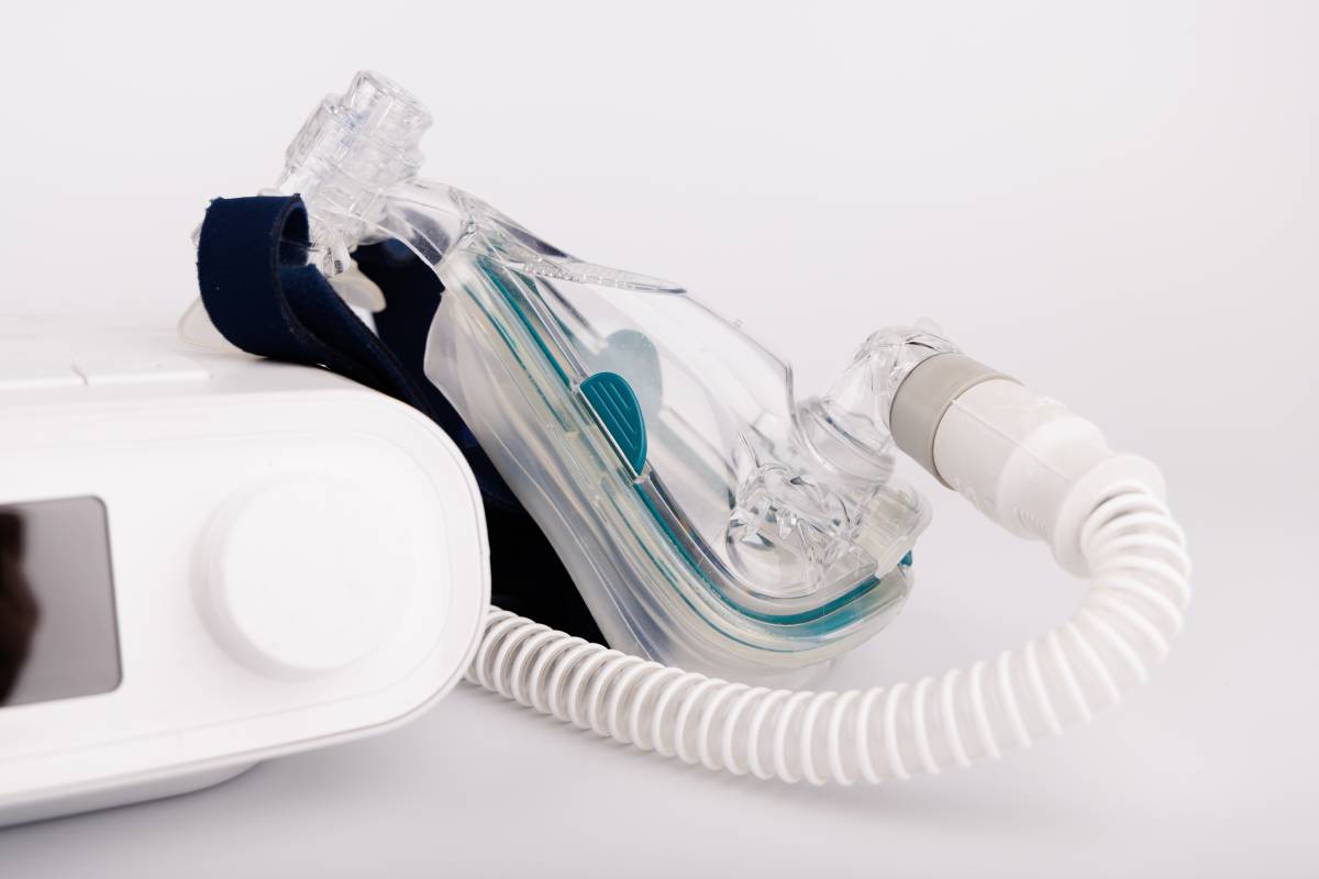 CPAP device with digital display, tubing, and mask for sleep disorder treatment on white background